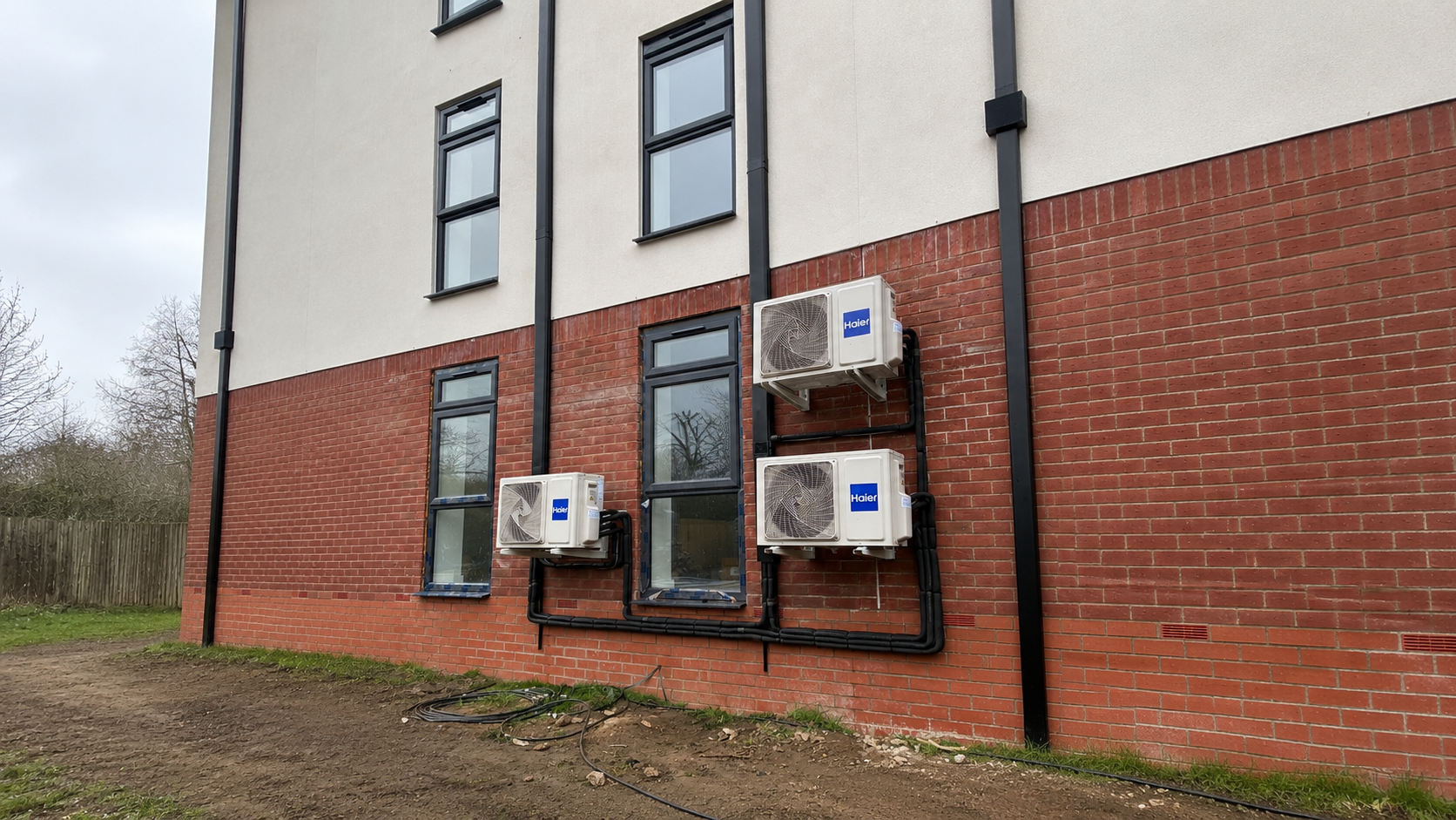 Haier air conditioning condenser units installed on a residential building by Fortifyd AC